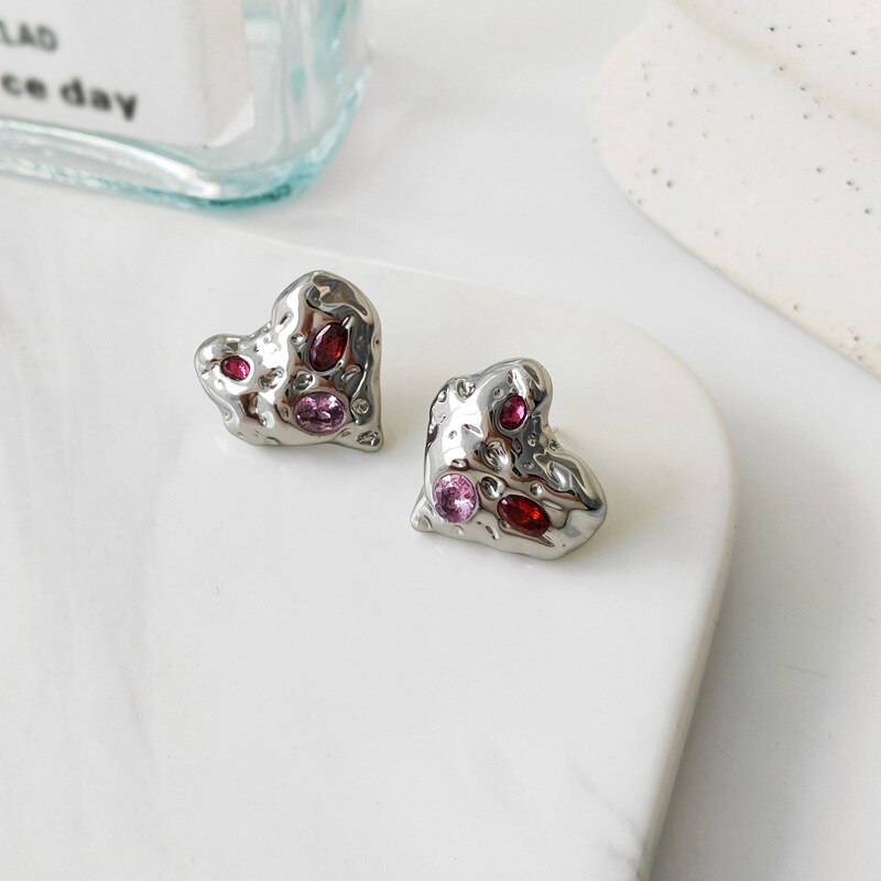 Silver heart shaped earrings that look like stones with red and pink crystals 